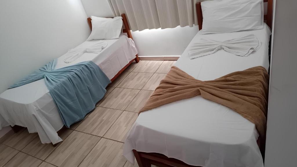 瓦拉达里斯州长市POUSADA BRASÃO的两张睡床彼此相邻,位于一个房间里