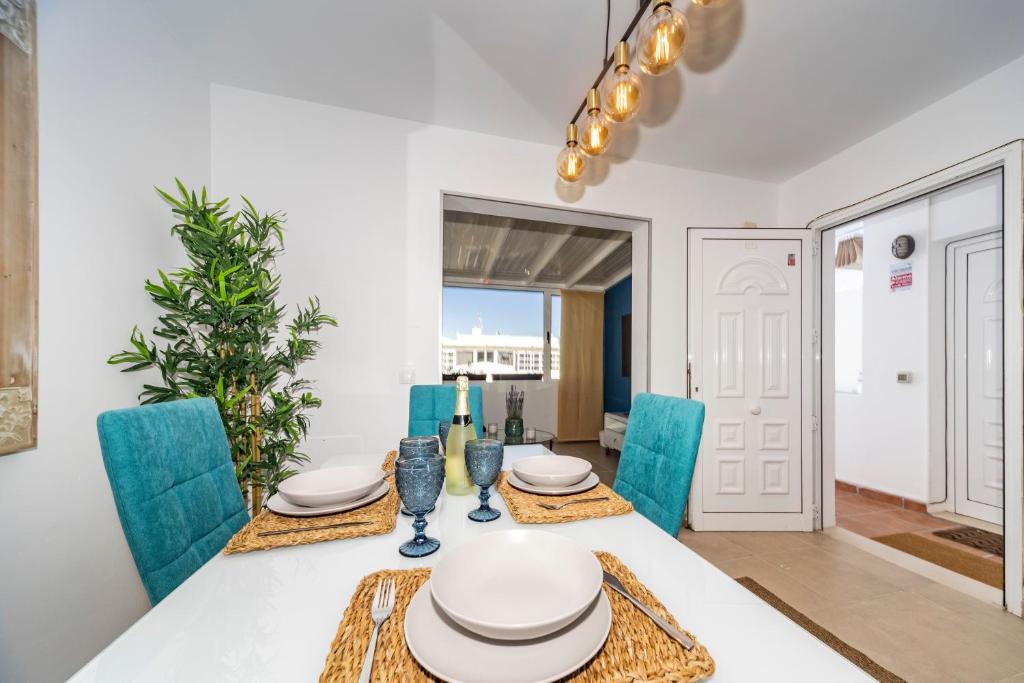 宏达海滩Luxury Apartment Chalana的一间带桌子和蓝色椅子的用餐室