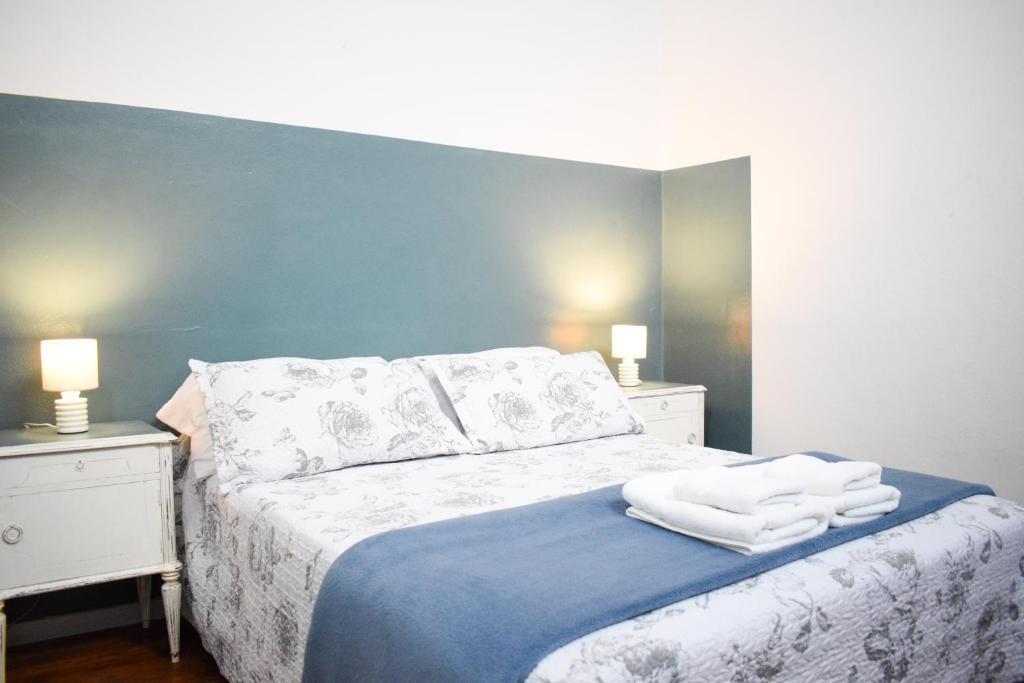 布宜诺斯艾利斯LOPEZ Hostel & Suites的一间卧室配有带毛巾的床