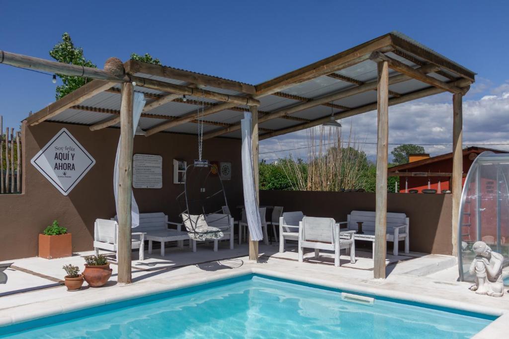 洛斯雷特斯Punta Piedra cabañas & suites的凉亭设有游泳池、椅子和桌子