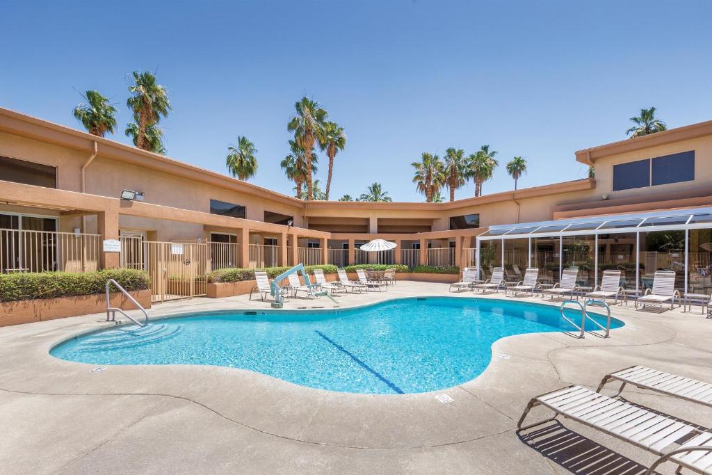 棕榈泉WorldMark Palm Springs - Plaza Resort and Spa的一座带椅子的游泳池以及一座建筑
