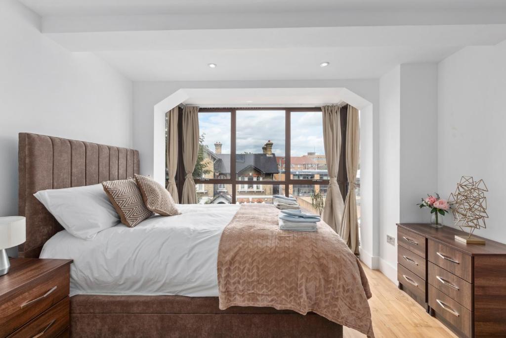 泰晤士河畔金斯顿Elegant Living in Kingston: Two Bedroom Apartment的一间卧室设有一张床和一个大窗户