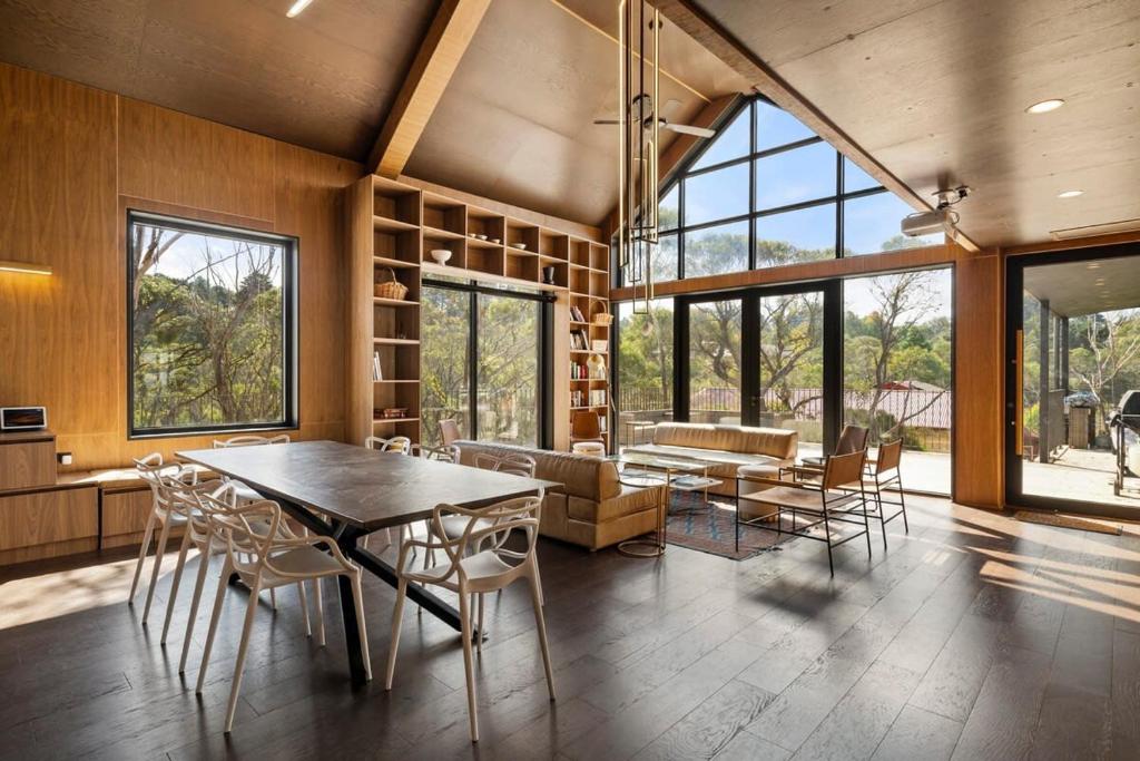 温特沃斯瀑布Sandbox House - Luxury Architectural Retreat的一间带桌椅和沙发的用餐室