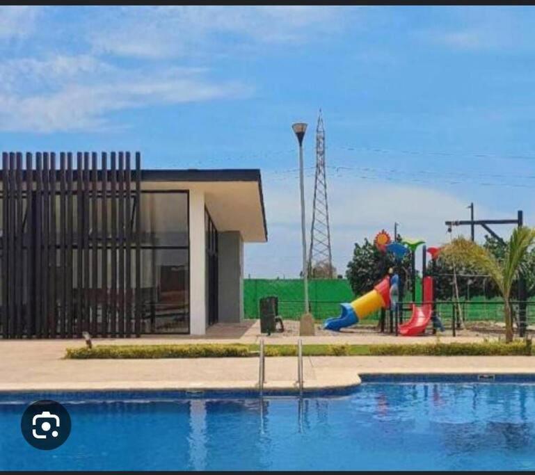 马萨特兰Departamento coto privado con alberca的一个带游乐场和滑梯的游泳池