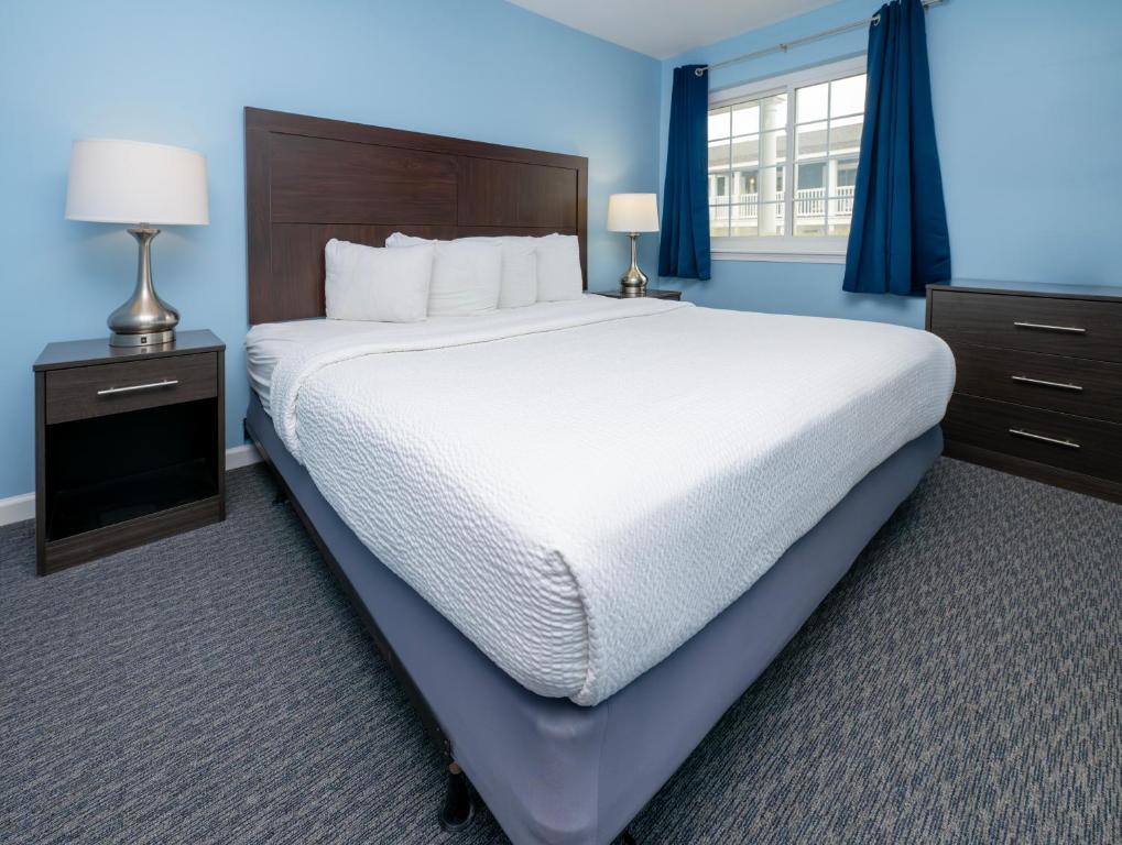 大洋城Commander Beach House Hotel的一张大床,位于拥有蓝色墙壁的房间