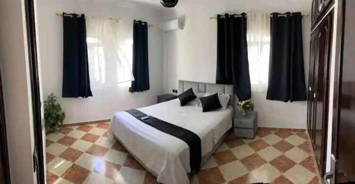 塞吉尔堡Chambres Maya的一间卧室配有一张大床和黑色窗帘