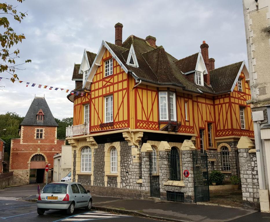 佩罗讷La Porte De Bretagne的一座橙色的建筑,前面有停车位