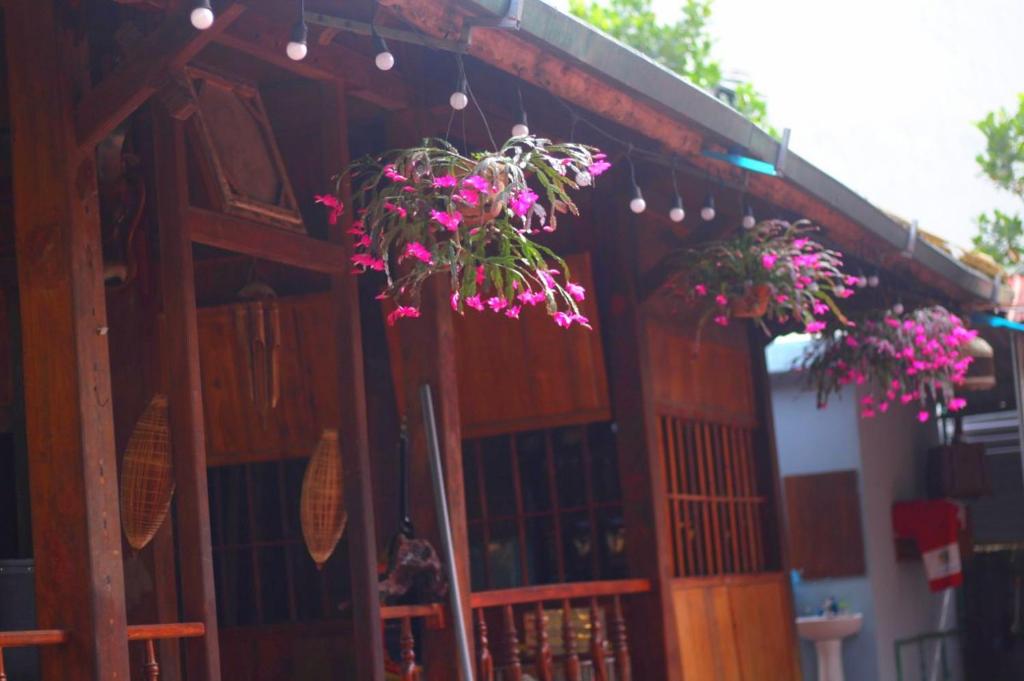 Bản HonPu Home Đỗ Quyên (Homestay Đỗ Quyên)的一座建筑,上面挂着粉红色的花