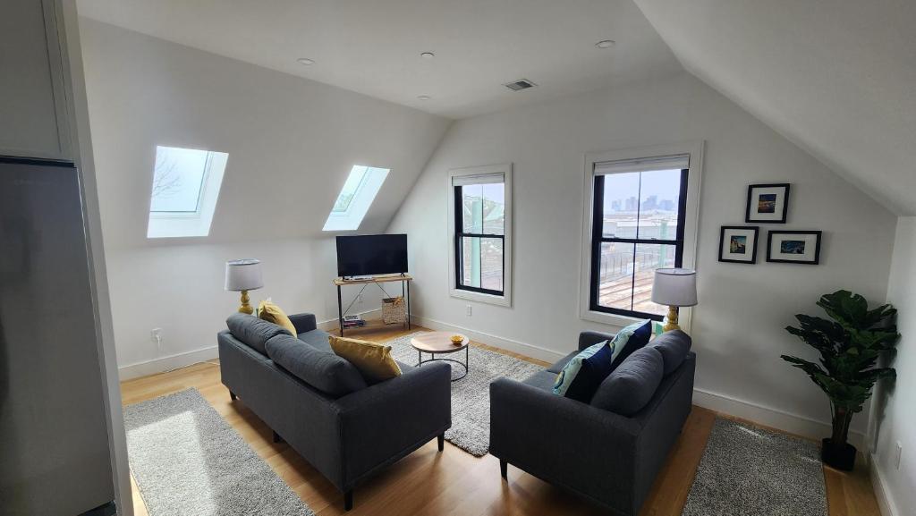 波士顿Ultra Convenient East Boston Luxury Condo的客厅配有两张沙发和一台电视机