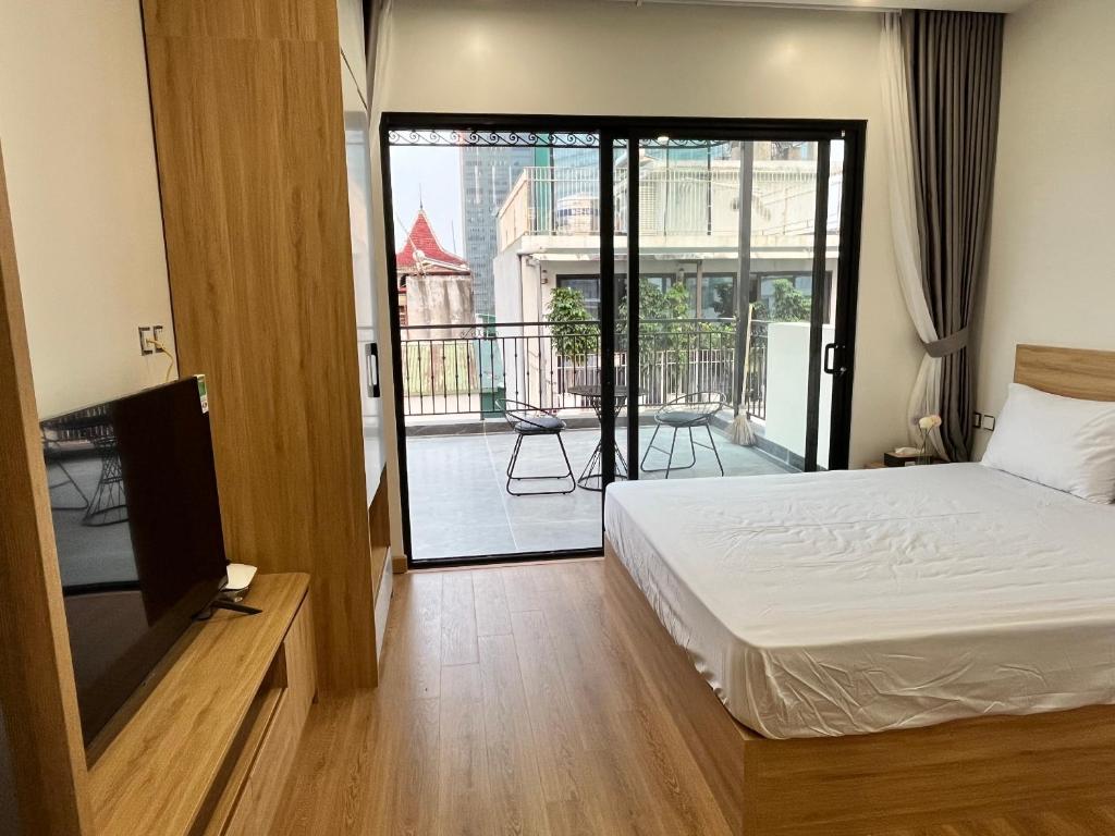 河内22Housing Luxury Apartment 81 Linh Lang的一间卧室设有一张床和一个阳台