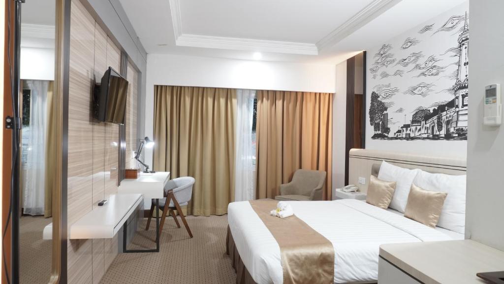日惹Abadi Hotel Malioboro Yogyakarta by Tritama Hospitality的配有一张床和一张书桌的酒店客房