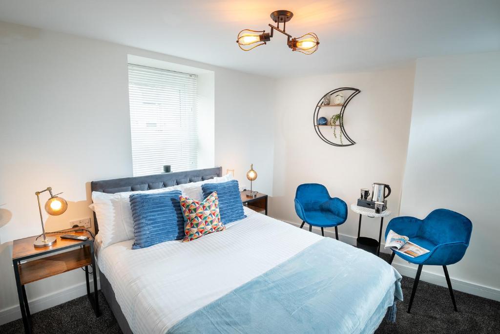 怀特黑Kings Arms Suites - Deluxe Room - En-Suite - Self Check In的一间卧室配有一张床和两张蓝色椅子