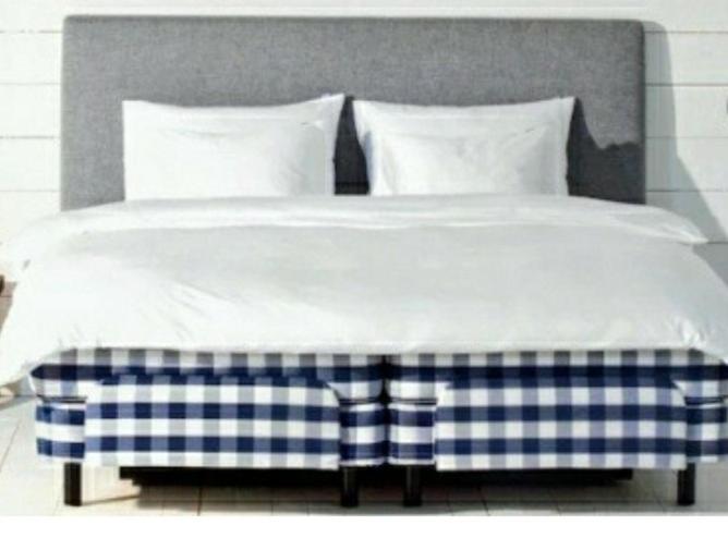 马尔默Relax huset的一张带蓝色和白色毯子及枕头的床