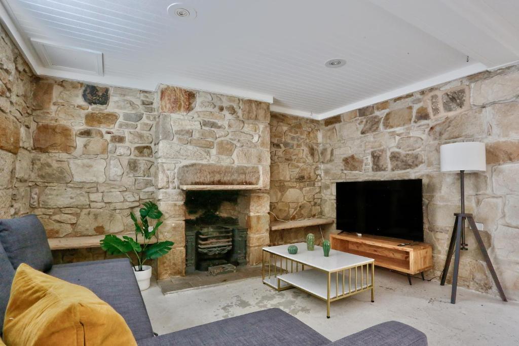 悉尼Spacious 3 Bedroom House Darlinghurst City Centre 2 E-Bikes Included的客厅设有带壁炉的石墙