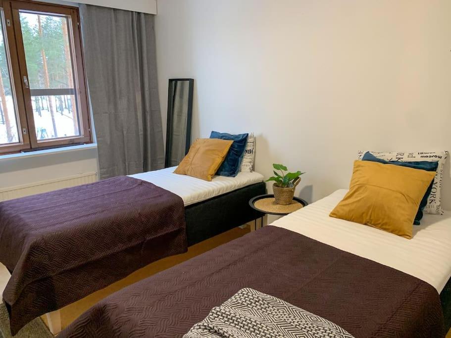 奥卢Tilava 2BR-huoneisto Saunalla的客房设有两张床和窗户。