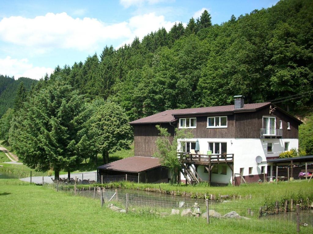 奥博瓦斯基德Apartment in Bruchhausen right on the fishing river的山丘旁田野的房子