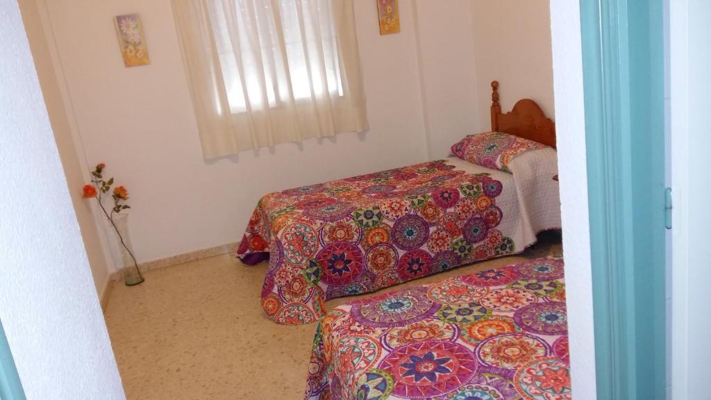 卡塔亚坎波马旅馆的一间卧室设有两张床和窗户。