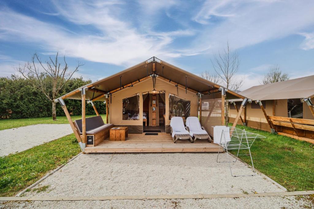 图赫尔斯克利普利采Glamping Tents in Tuhelj with thermal riviera tickets的一个带两把椅子和门廊的大型帐篷