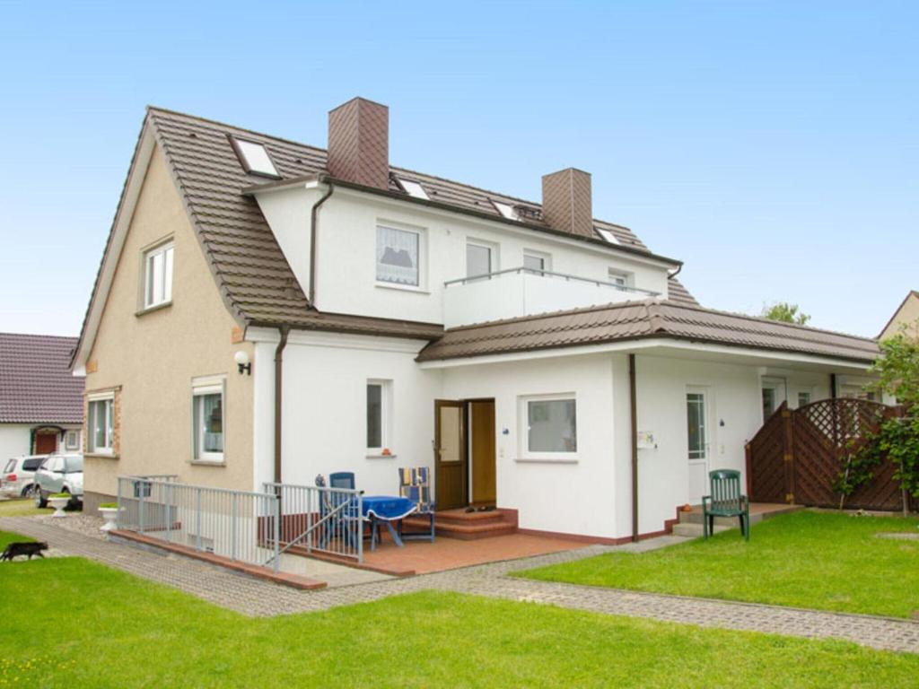 奥斯特巴德里克Tasteful Apartment in Rerik Germany with Garden的白色的房子,设有门廊和院子