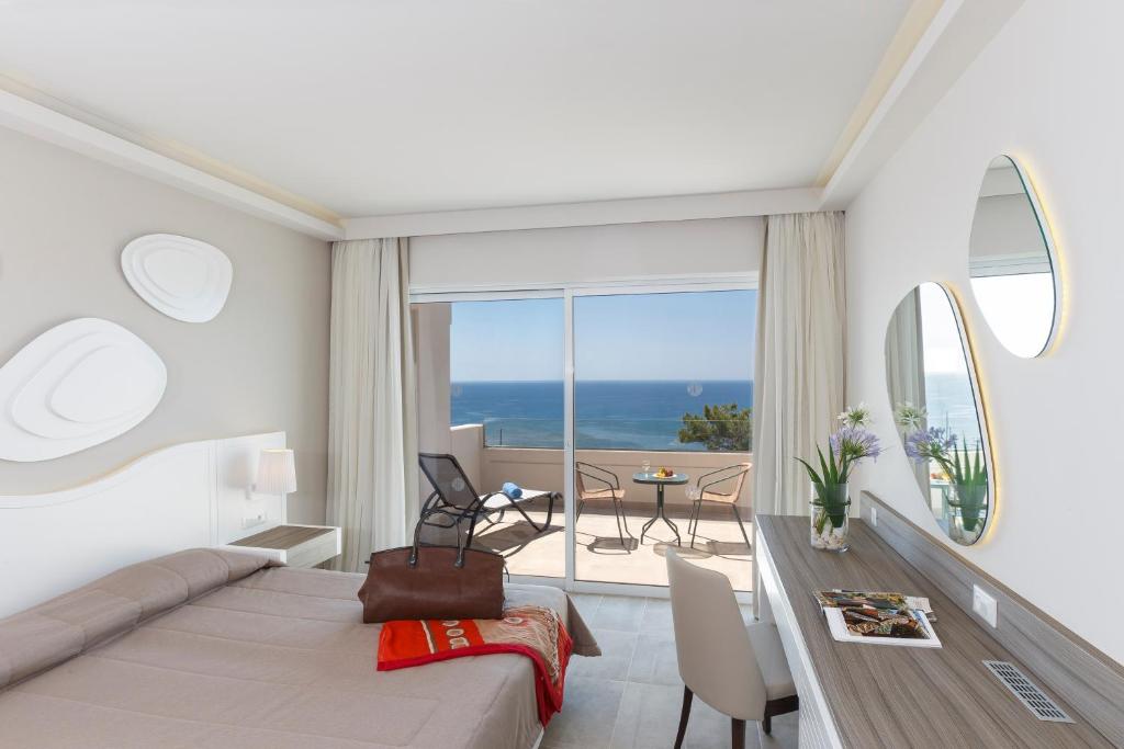 吉奥塔略罗德公主海滩酒店的一间卧室配有一张床,一间享有美景的用餐室