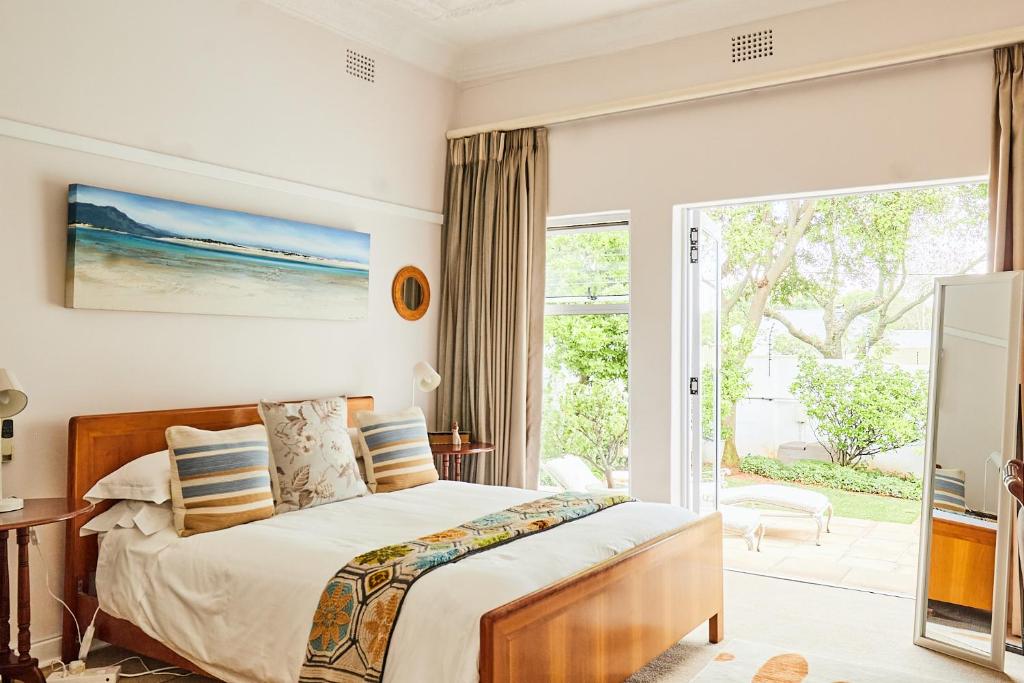 约翰内斯堡Maison Jacaranda的一间卧室设有一张床和一个滑动玻璃门