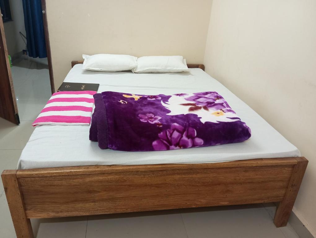 因帕尔ALPHA Hotel的床上有紫色毯子