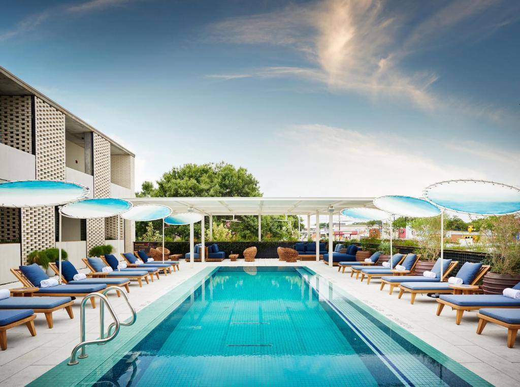 奥斯汀南国会区酒店的一个带躺椅和遮阳伞的游泳池