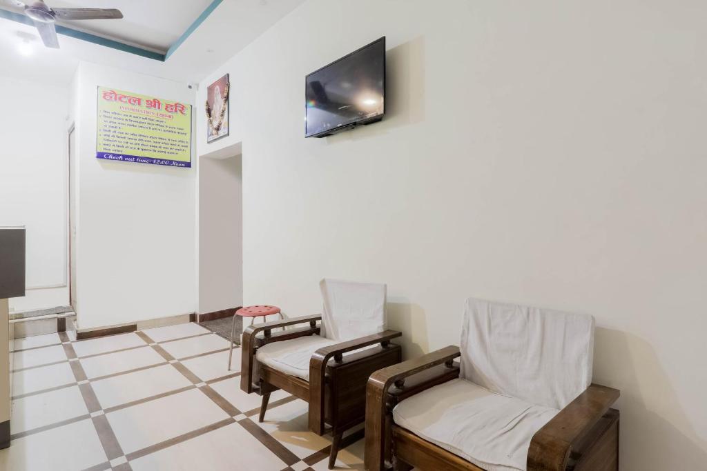 BihtaOYO Hotel Sri Hari的一间设有两把椅子和电视的等候室
