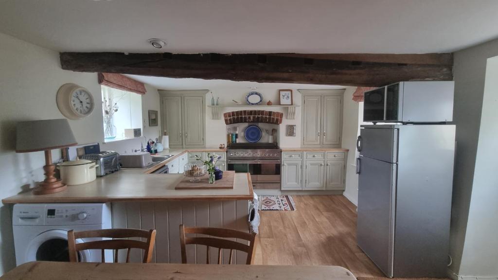 赛伦塞斯特Characterful Cotswold cottage的厨房配有冰箱和桌椅