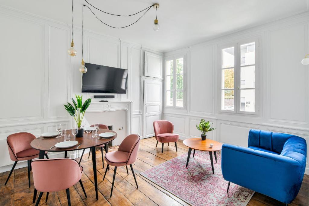 雷恩Appartements Le 31bis的客厅配有桌椅和电视。