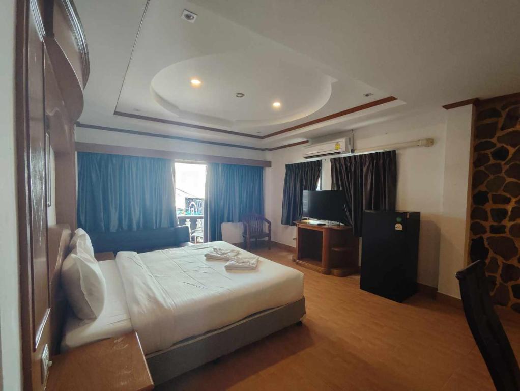 芭东海滩Rock Shore Patong的酒店客房,配有床和电视