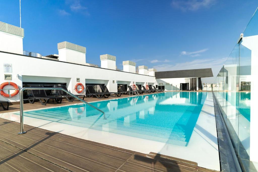 塞维利亚Hotel Giralda Center的建筑物屋顶上的游泳池