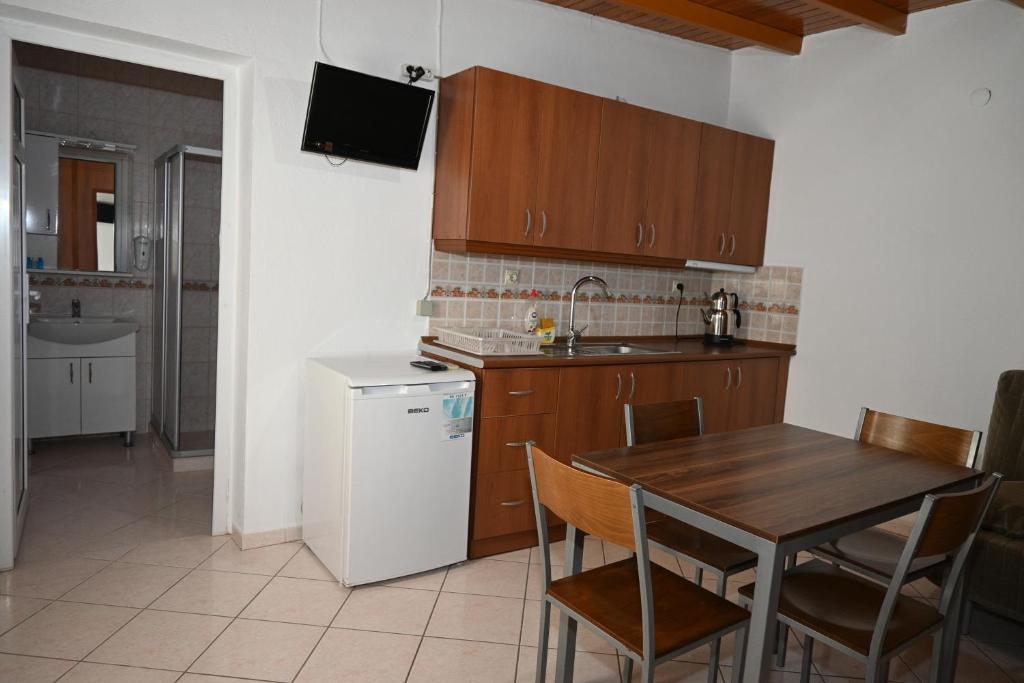 博德鲁姆梅利斯畔丝咏酒店的厨房配有木桌和白色冰箱。