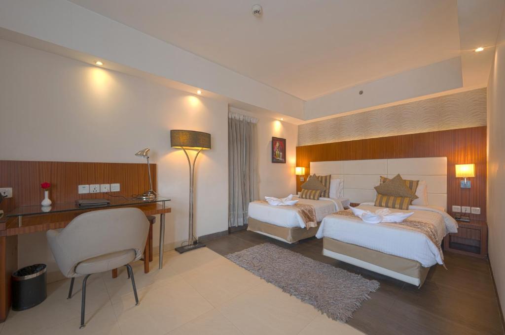 加尔各答切莱斯塔 - 加尔各答酒店的酒店客房配有两张床和一张书桌