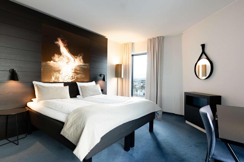 波多斯堪迪克霍伟特酒店的酒店客房设有一张大床和一张书桌。