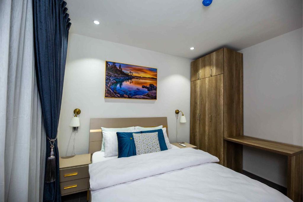阿克拉Park Apartments的一间卧室配有白色床和蓝色枕头