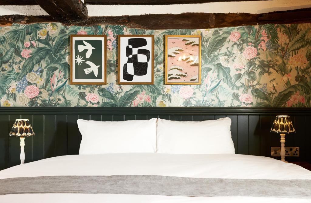 NarboroughNarborough Arms的一间卧室配有一张床和花卉壁纸