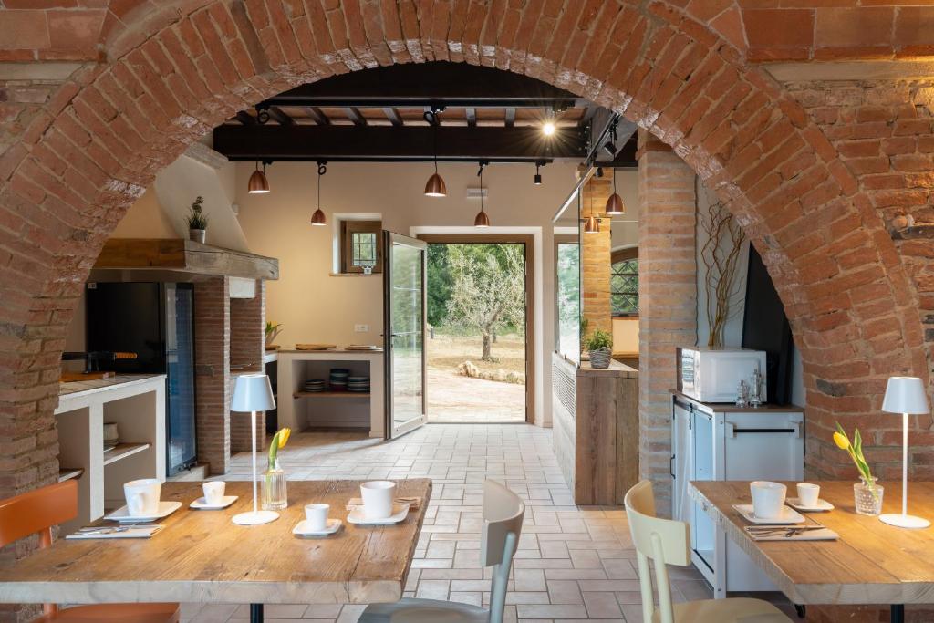 科莱萨尔韦蒂Tenuta i 4 venti的开放式厨房和带砖拱门的用餐室