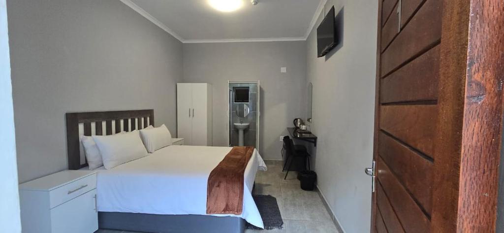 德班Abay Lodge的卧室配有白色的床和木门