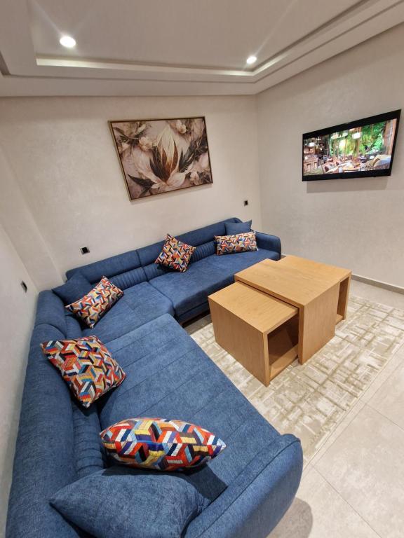纳祖尔Hotel Residence Ramsis的客厅配有蓝色的沙发和木桌