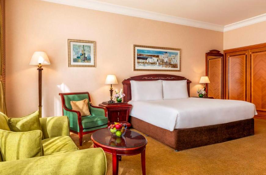 阿布扎比Al Raha Beach Hotel - Superior Room SGL - UAE的酒店客房配有一张床、两把椅子和一张桌子
