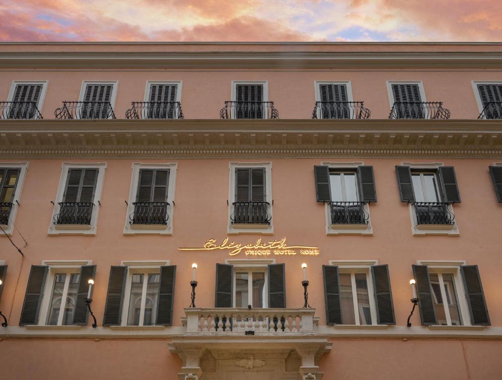 罗马伊丽莎白独特酒店|设计酒店™成员的粉红色的建筑,设有窗户和阳台