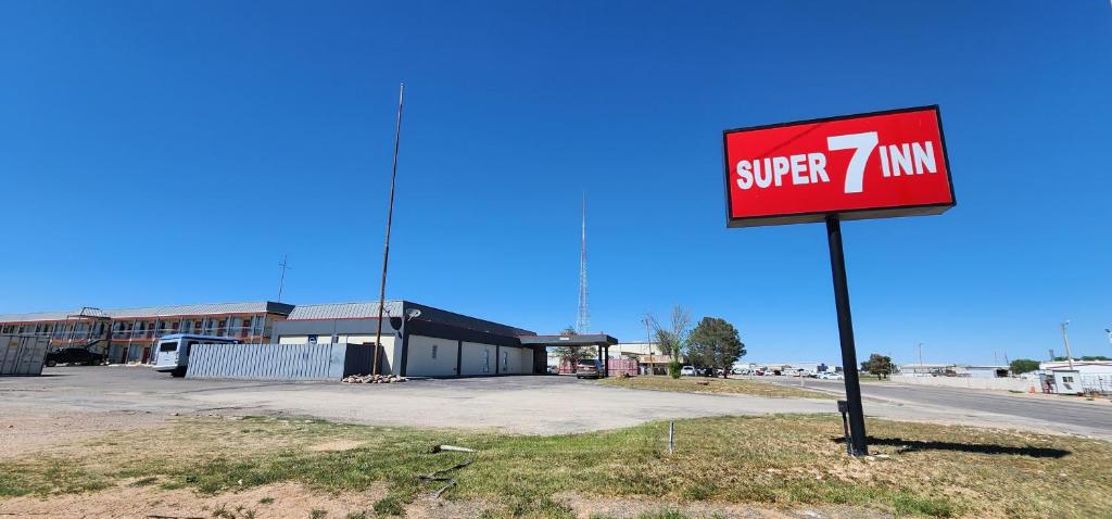 米德兰Super 7 Inn的大楼前的标志,上面有一辆超级面包车