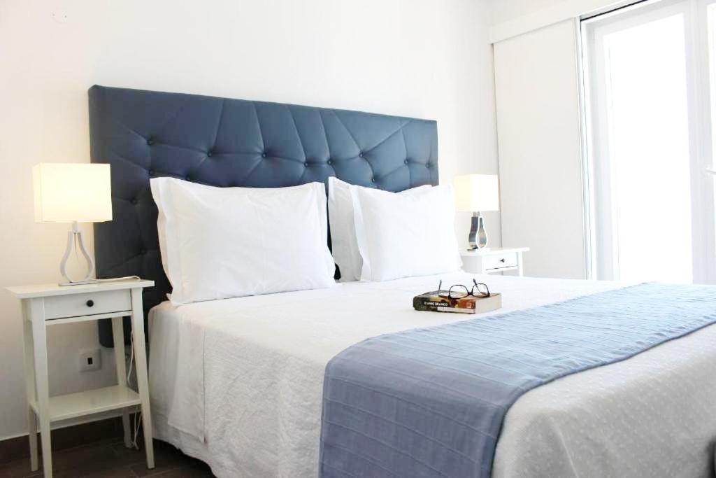 米尔芳提斯城River Inn - Duna Parque Group的一间卧室配有一张大床和蓝色床头板