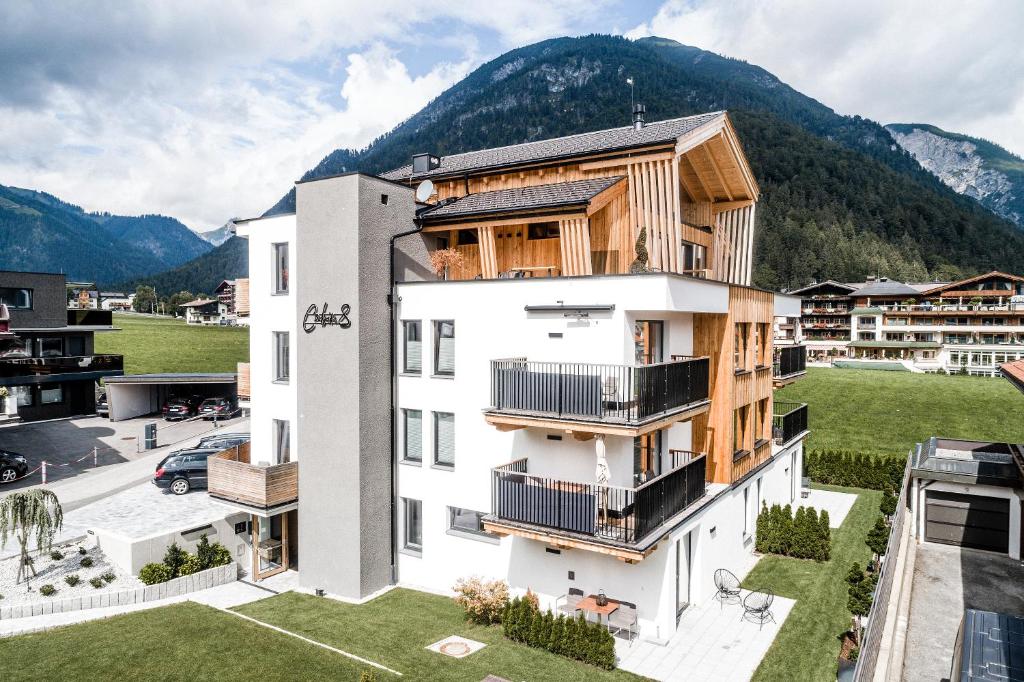 佩尔蒂绍Cabin8 Alpine Flair Apartments的公寓大楼设有木制阳台,享有山脉的背景
