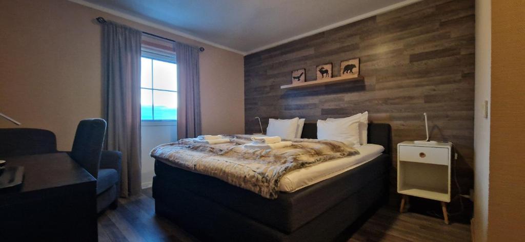 StrandeKvitfjell Hotel的一间卧室配有一张木墙床。