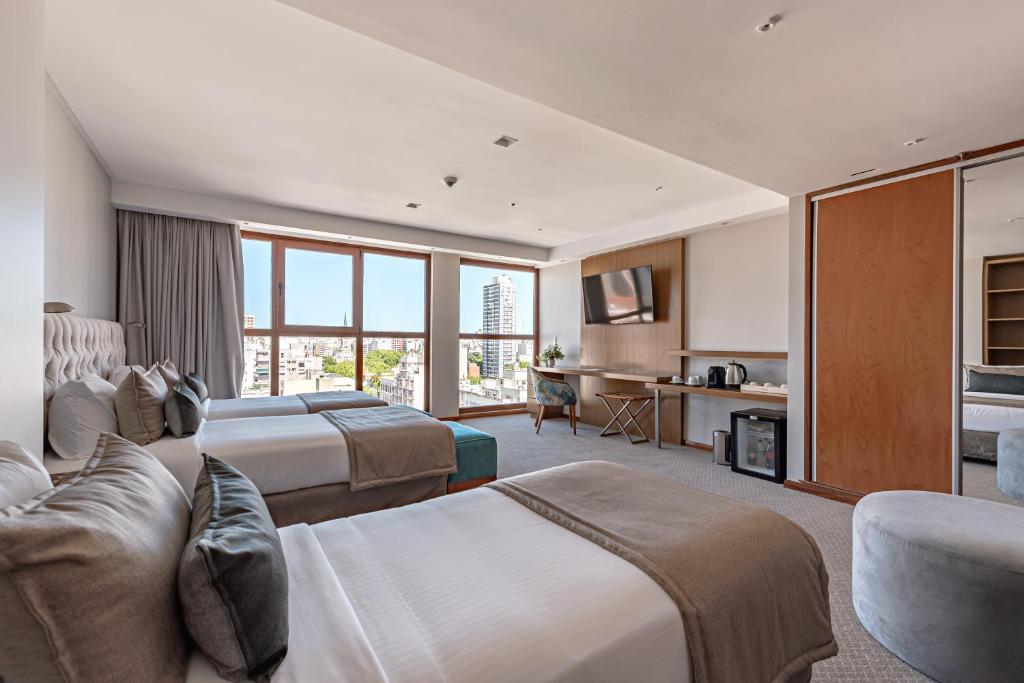 马德普拉塔HOTEL KONKE MAR DEL PLATA的酒店客房,设有两张床和一张沙发
