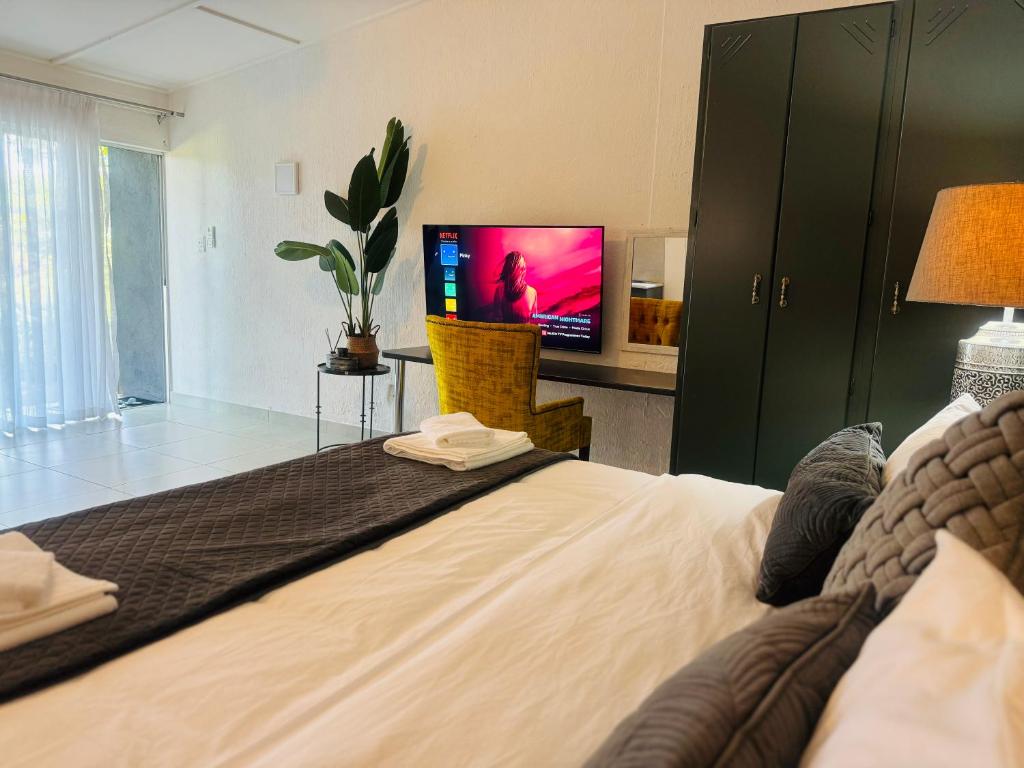 白河Busa House的一间卧室设有一张大床,配有电视