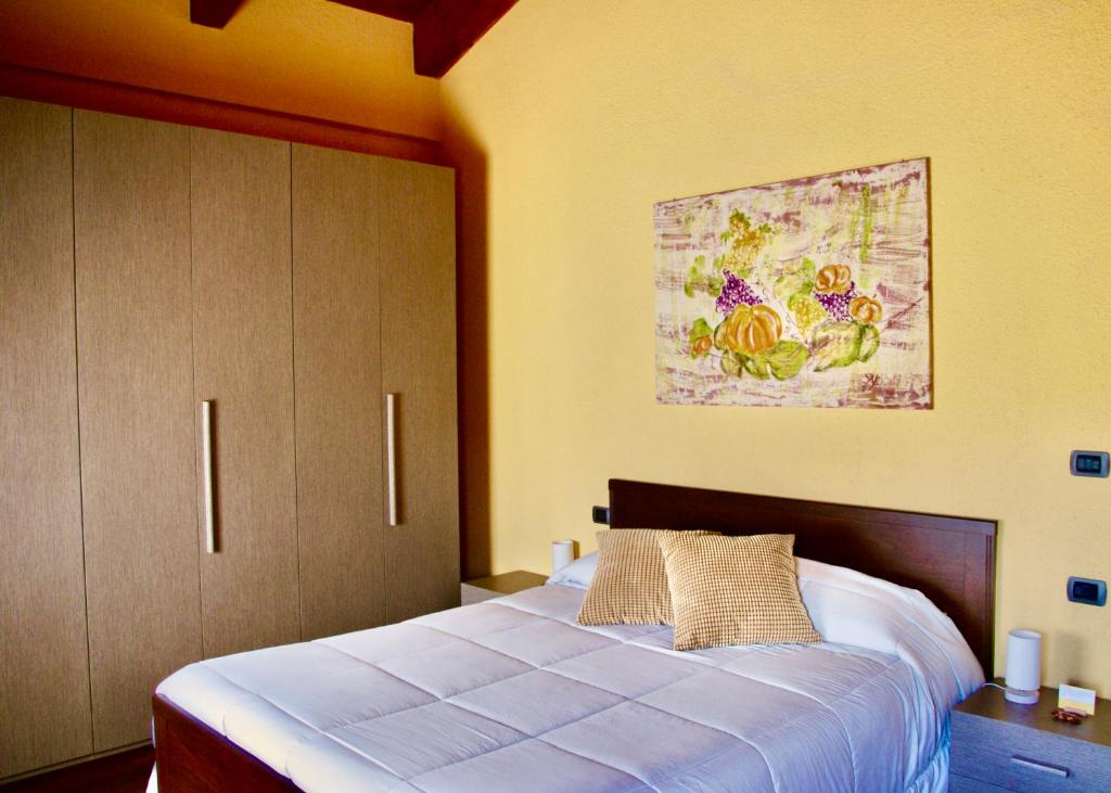 博洛尼亚Podere Boschetto R&B的卧室配有一张床,墙上挂有绘画作品