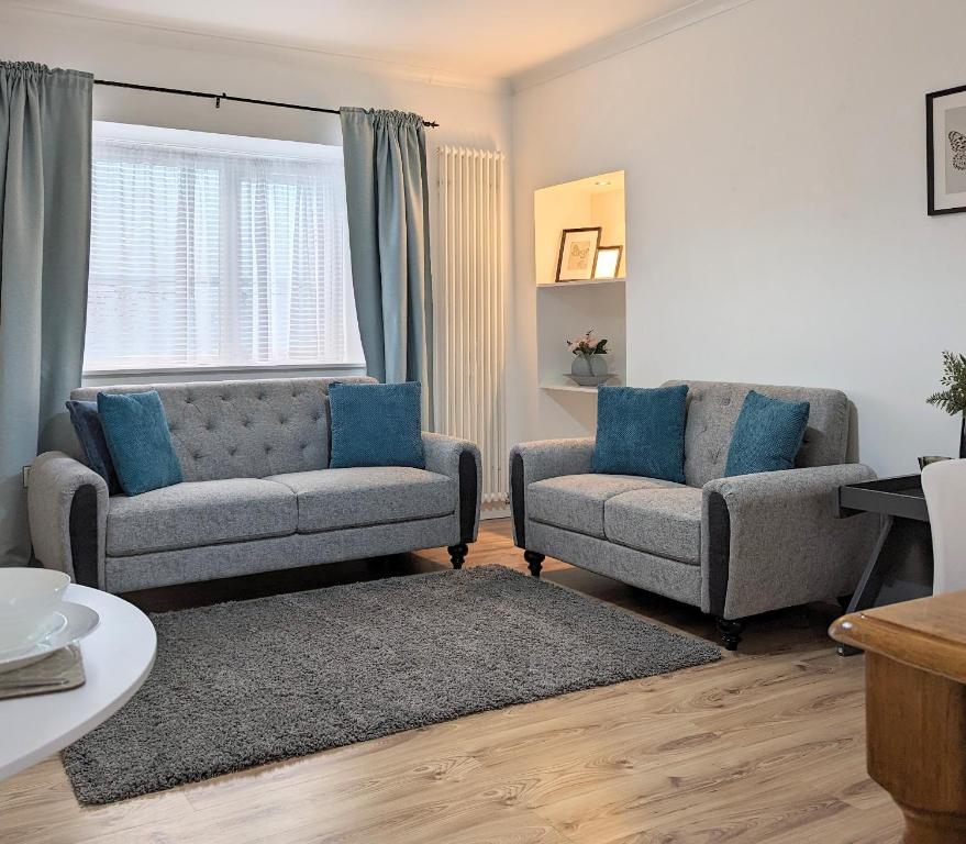 坎贝尔城Erradale的客厅配有两把椅子、一张沙发和一个窗口